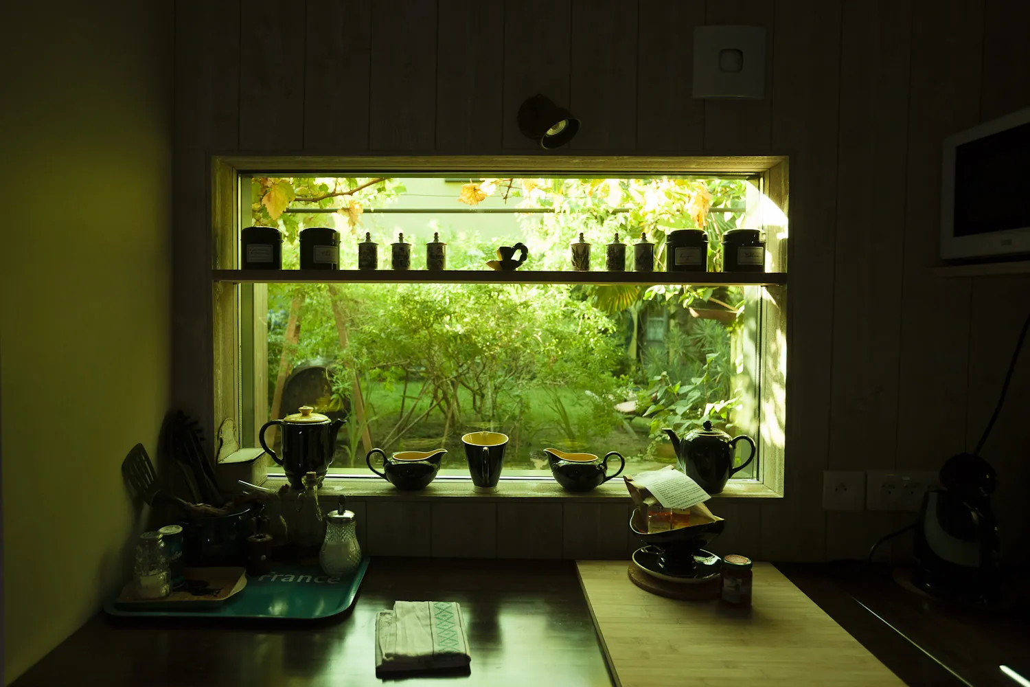 Coin cuisine avec fenêtre donnant sur le jardin verdoyant