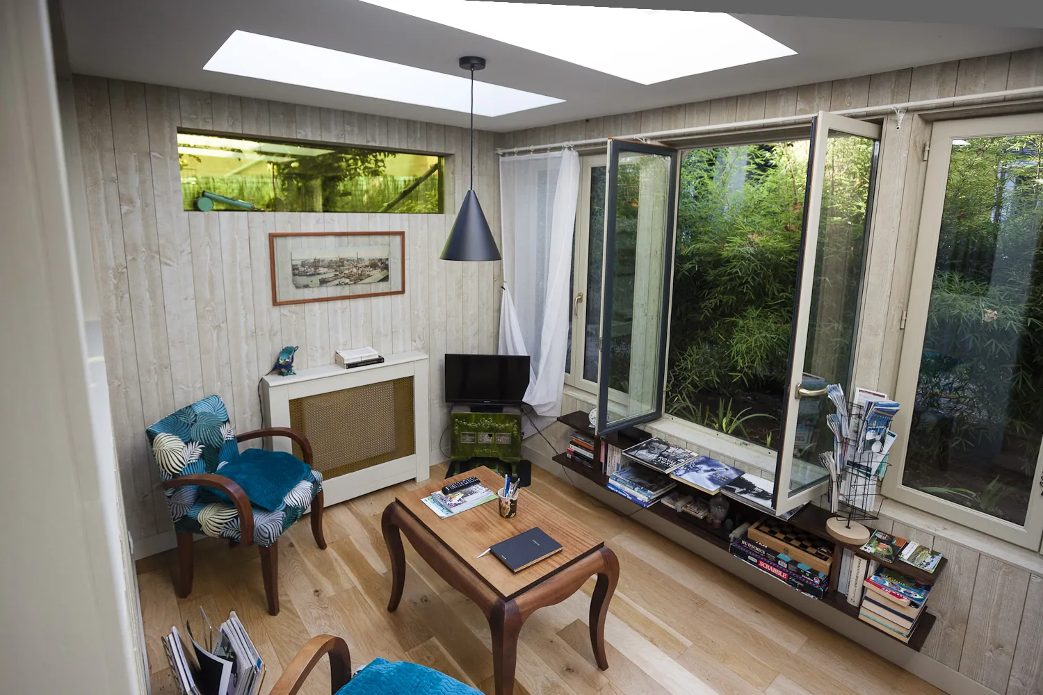 Coin lecture face aux fenêtres ouvertes sur le jardin